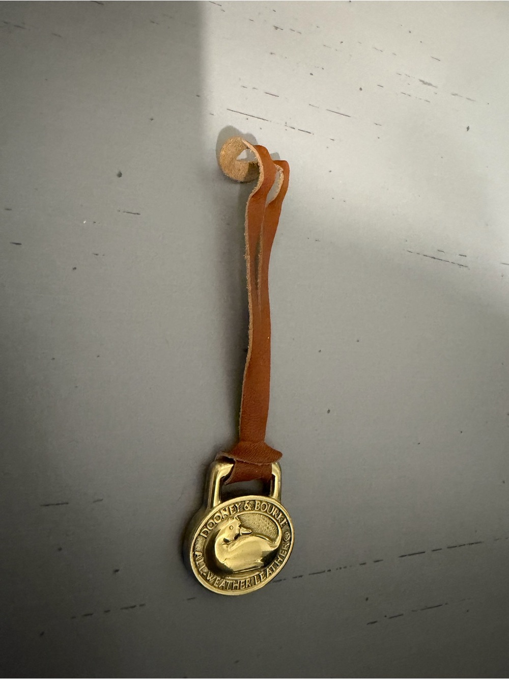 Dooney & Bourke Tan and gold purse charm with Brass Medallion